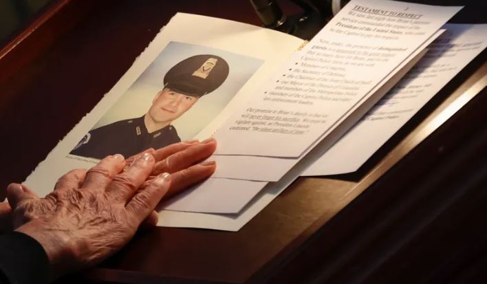 Nancy Pelosi holds a portrait of the late Capitol Police Officer Brian Sicknick who lies in honor in the Capitol rotunda on February 3, 2021.